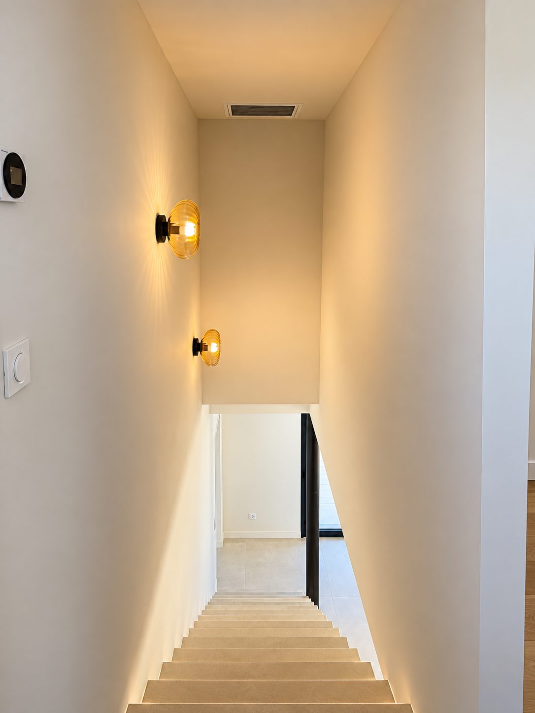 L'escalier qui mène à l'étage, éclairé d'appliques