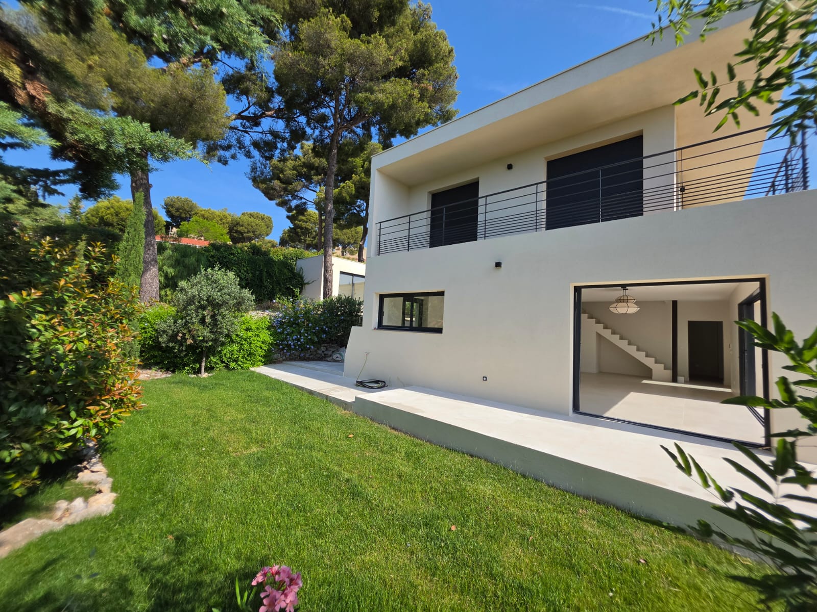 La façade côté jardin, baies grandes ouvertes sur la pelouse