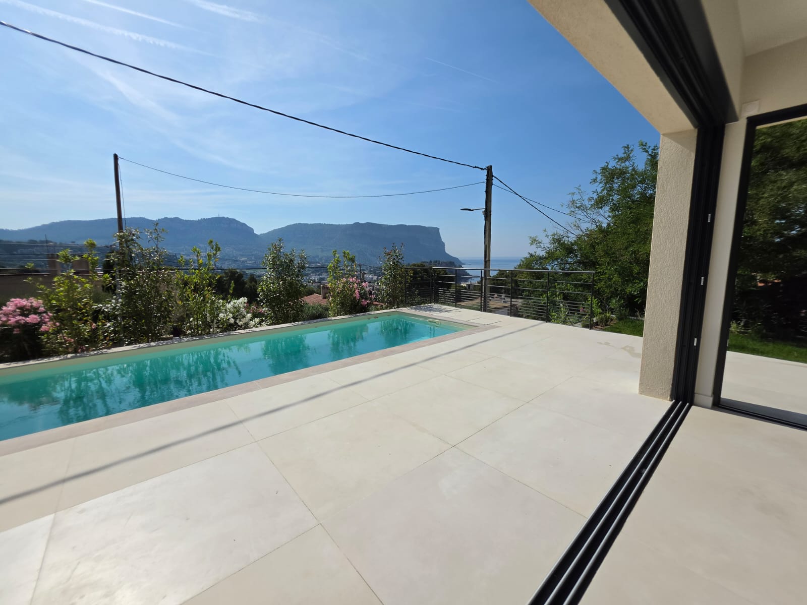 Les baies à galandage ouvertes sur la terrasse, la piscine et le Cap Canaille