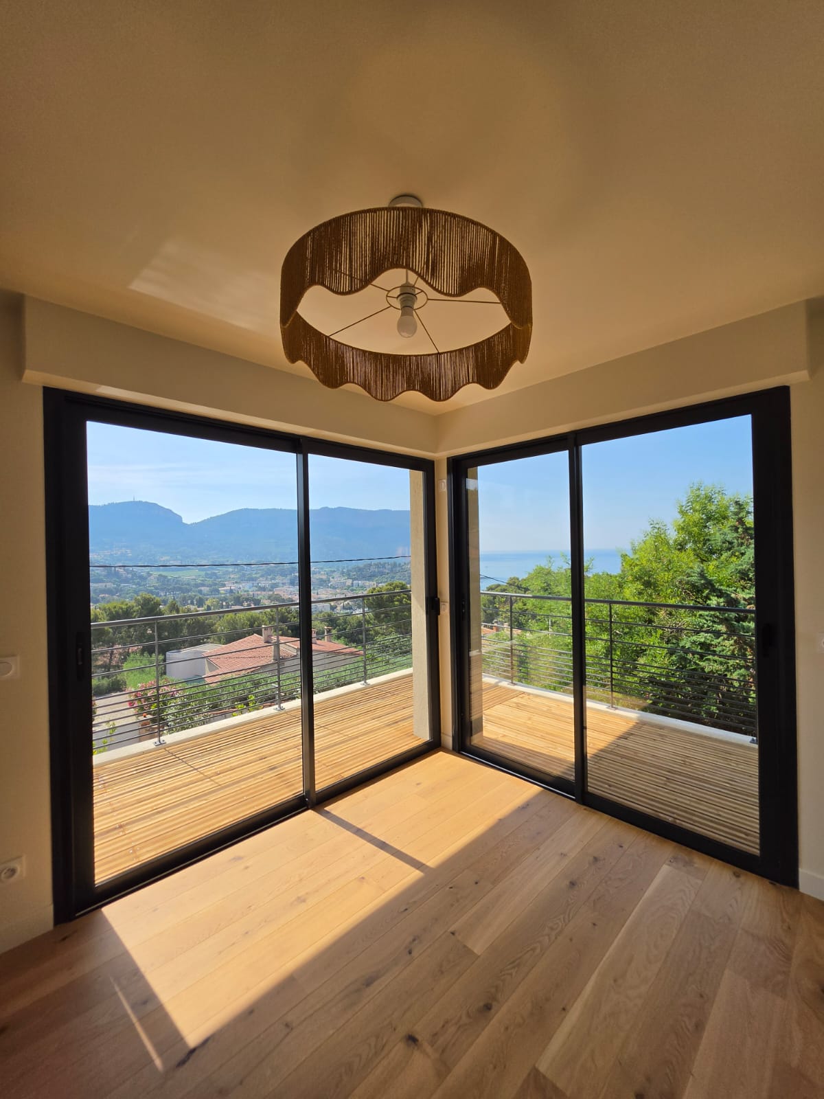 Les baies d'angle de la suite et la terrasse en bois, vue mer