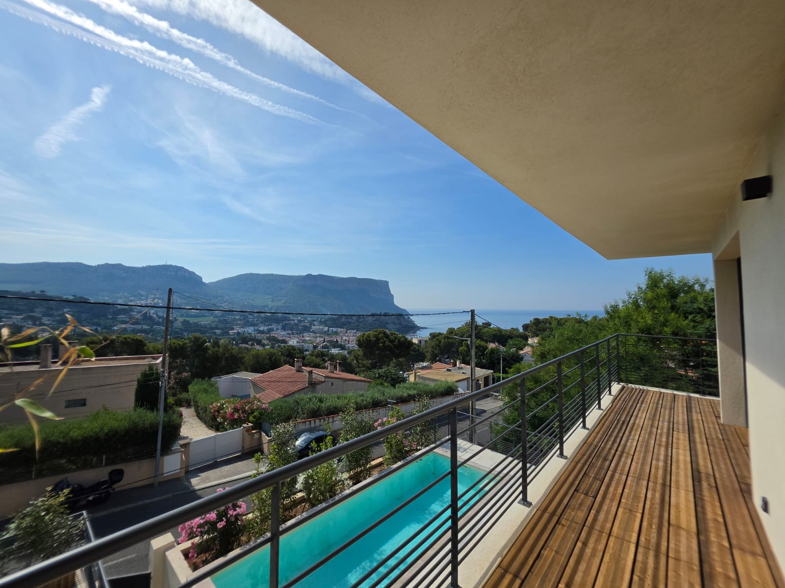 La terrasse de l'étage surplombant la piscine, vue sur la baie